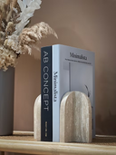 Arched travertine marble bookends styled on a shelf